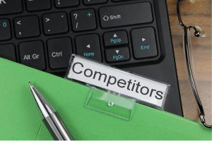 laptop and a competitors written on a note